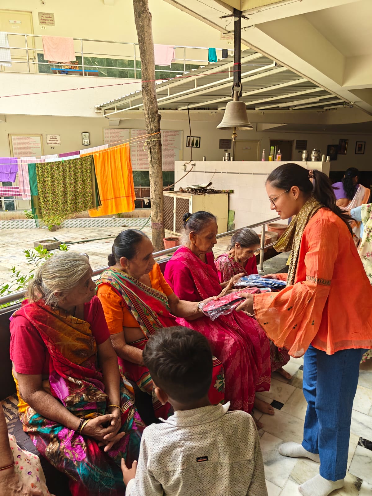 A volunteer spending time with elders at a seva home