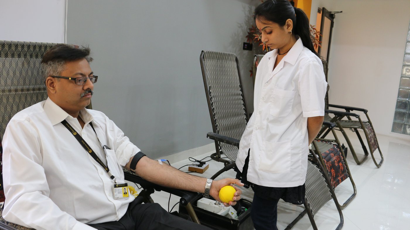 A donor giving blood at a camp